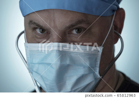 Portrait of tired doctor. Doctor wearing medical mask looking into camera Portrait of tired doctor. Doctor wearing medical mask looking into camera 65812963
