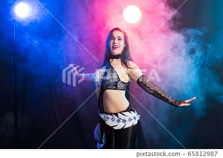 Girl dancing belly dance, fusion or tribal. A woman in a beautiful costume demonstrates charming and gentle movements in the dance. 65812987