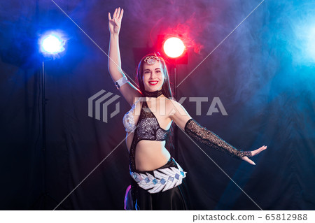 Young woman dancing in Tribal Fusion style. Belly dance on the stage. 65812988