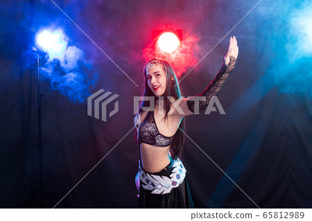 Spirituality dance. Beautiful sexy woman with luxury glossy eastern make-up dancing tribal fusion. Belly dance. 65812989