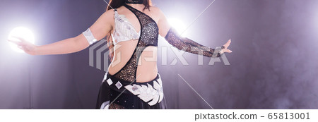 Spirituality dance. Beautiful sexy woman with luxury glossy eastern make-up dancing tribal fusion. Belly dance. Close-up. Spirituality dance. Beautiful sexy woman with luxury glossy eastern make-up dancing tribal fusion. Belly dance. Close-up. 65813001
