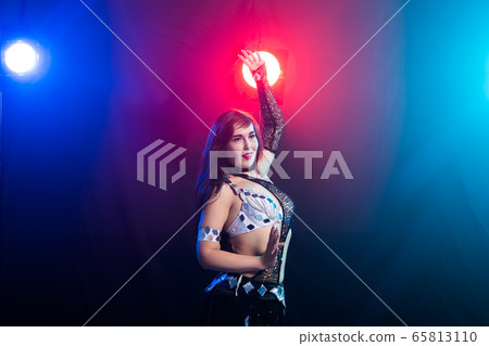 Young woman dancing in Tribal Fusion style. Belly dance on the stage. Copy space. 65813110