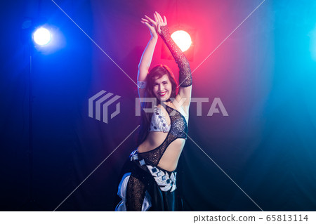 Young woman belly dancer in exotic dress with gold, dancing tribal fusion dance in studio. 65813114