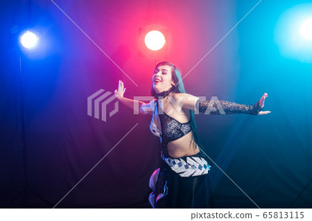 Young woman dancing in Tribal Fusion style. Belly dance on the stage. 65813115