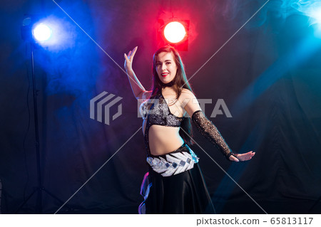 Portrait of a woman in oriental costume performing belly dance. Tribal fusion dance concept. Portrait of a woman in oriental costume performing belly dance. Tribal fusion dance concept. 65813117