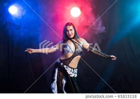 Spirituality dance. Beautiful sexy woman with luxury glossy eastern make-up dancing tribal fusion. Belly dance. 65813118