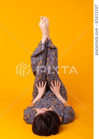 Excited young woman with black hair in home wear pajama, widely smiling having fun. Isolated on yellow background. Copy spase. Excited young woman with black hair in home wear pajama, widely smiling having fun. Isolated on yellow background. Copy spase. 65813187