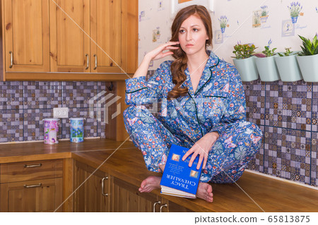 Young red-haired woman relaxing at home with books. Quarantine, isolation, coronavirus pandemic world. Stay at home. 65813875