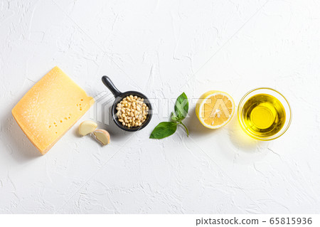 Different ingredients for Italian pesto. basil leaves, pine nuts, olive oil, garlic and salt. Traditional Italian cuisine. Top view. Onwhite textured background Different ingredients for Italian pesto. basil leaves, pine nuts, olive oil, garlic and salt. Traditional Italian cuisine. Top view. Onwhite textured background 65815936