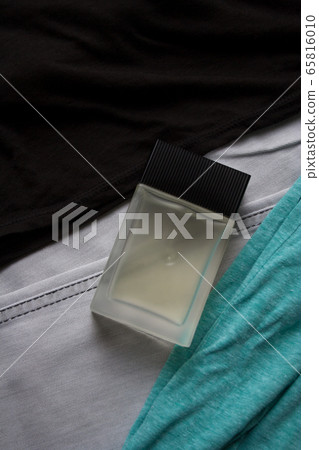 Glass perfume bottle on black and mint tank tops and light grey jeans Glass perfume bottle on black and mint tank tops and light grey jeans 65816010