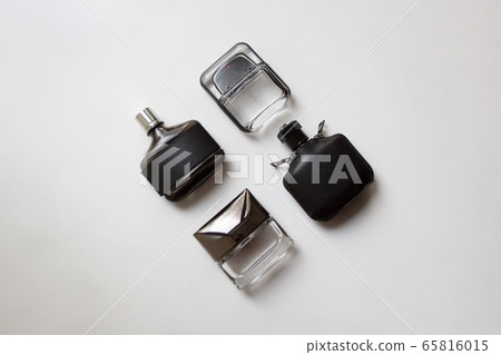 Four glass perfume bottles isolated on white background from a high angle view Four glass perfume bottles isolated on white background from a high angle view 65816015