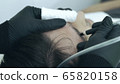 Close up of cosmetologist making permanent makeup. Microblading procedure. High quality close-up of a man laying on a couch during the esthetician brow microblading treatment. 65820158