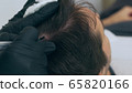 High quality close-up of a man laying on a couch during the esthetician hair treatment. Male tricopigmentation service. Scalp micropigmentation treatment. Trichopigmentation procedure. 65820166