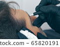 Close up of cosmetologist making permanent makeup. Microblading procedure. High quality close-up of a man laying on a couch during the esthetician brow microblading treatment. 65820191