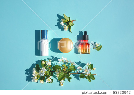 Set of beauty products flat lay on a blue background. The concept of natural cosmetics. Serum, cream skin care, minimal 65820942
