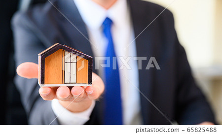 Property investment and house mortgage financial concept. Business man showing home model 65825488