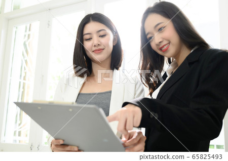 Two beautiful young asian business woman people have fun and talking Two beautiful young asian business woman people have fun and talking 65825493