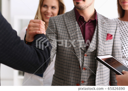 Smiling man and woman shake hands as hello in office 65826890