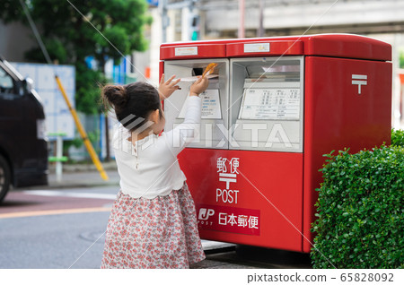 Girl posting a letter to the post 65828092
