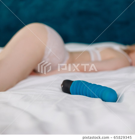 View on blue rubber sexy toy with sexy blonde woman in white lingerie. View on blue rubber sexy toy with sexy blonde woman in white lingerie. 65829345