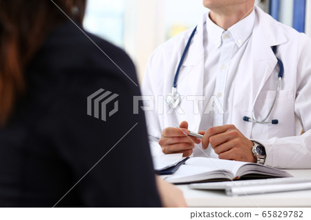 Male doctor hands hold silver pen discuss problem 65829782