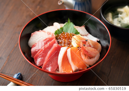 Bowl of rice topped with sashimi  65830519