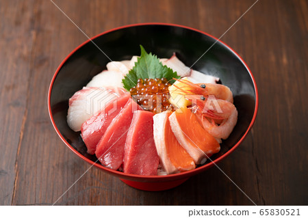Bowl of rice topped with sashimi  65830521