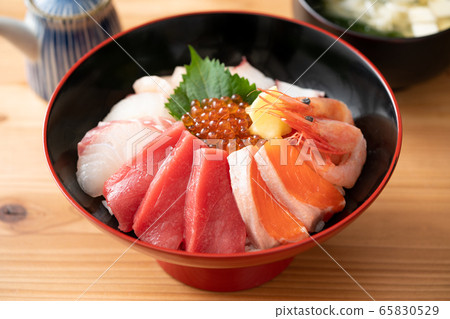 Bowl of rice topped with sashimi  65830529