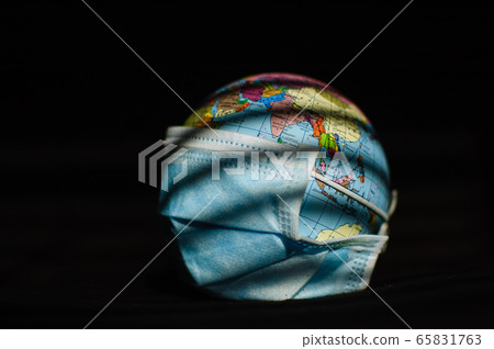 Earth globe with geografical names in Ukrainian cyrillic letters on it dressed in a surgical mask on black background. Coronavirus epidemic in world, pandemic danger, global quarantine concept 65831763