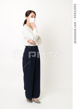 A woman wearing a mask and arms folded (facing left) A woman wearing a mask and arms folded (facing left) 65832891