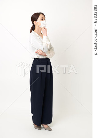 一名婦女戴著口罩,雙臂交叉(朝左) 一名婦女戴著口罩,雙臂交叉(朝左) 65832892