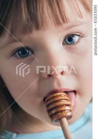 The child eats honey. Selective focus.  65833095