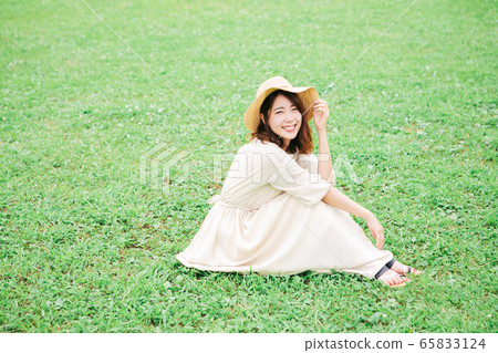 A young lady sitting on the lawn A young lady sitting on the lawn 65833124