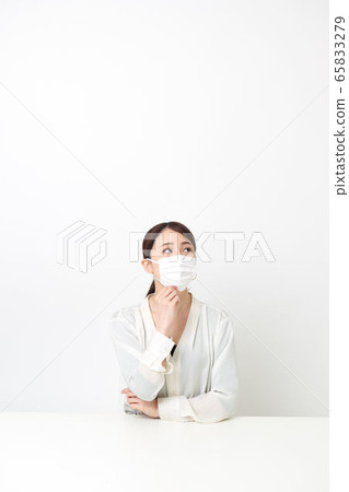 戴著面具和雙臂交叉坐著的女人 戴著面具和雙臂交叉坐著的女人 65833279