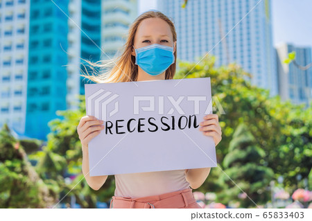 woman in medical mask prevents coronavirus disease holds a poster RECESSION Hand written text - woman in medical mask prevents coronavirus disease holds a poster RECESSION Hand written text - 65833403