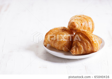 croissant on plate on wooden background. 65840416