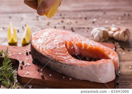 Fish Menu. Cook man plating salmon steak squeezing lemon juice. Selective Focus Fish Menu. Cook man plating salmon steak squeezing lemon juice. Selective Focus 65841000