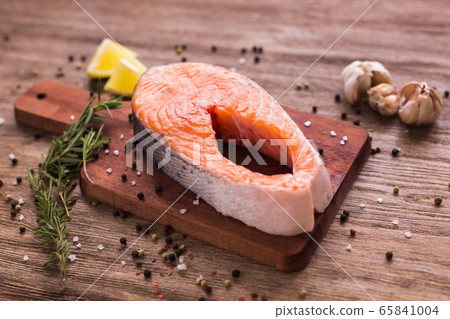 Fresh salmon fillet on a board, food close up. Diet, omega vitamins and seafood concept. Fresh salmon fillet on a board, food close up. Diet, omega vitamins and seafood concept. 65841004