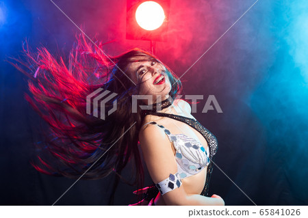 Young woman belly dancer in exotic dress with gold, dancing tribal fusion dance in studio. Young woman belly dancer in exotic dress with gold, dancing tribal fusion dance in studio. 65841026