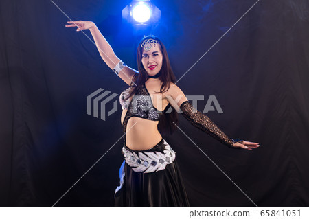 Young woman dancing in Tribal Fusion style. Belly dance on the stage. Young woman dancing in Tribal Fusion style. Belly dance on the stage. 65841051