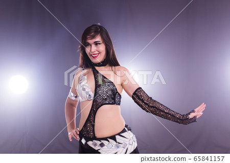 Young woman dancing in Tribal Fusion style. Belly dance on the stage. Young woman dancing in Tribal Fusion style. Belly dance on the stage. 65841157