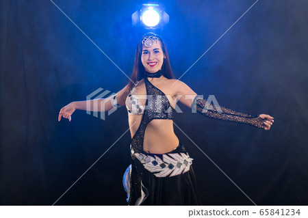 Spirituality dance. Beautiful sexy woman with luxury glossy eastern make-up dancing tribal fusion. Belly dance. Spirituality dance. Beautiful sexy woman with luxury glossy eastern make-up dancing tribal fusion. Belly dance. 65841234