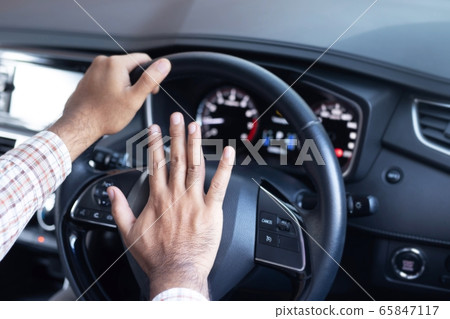 Man honking car horn for safety 65847117