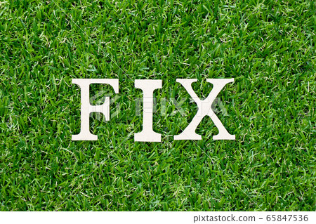 Wood letter in word fix on green grass background 65847536