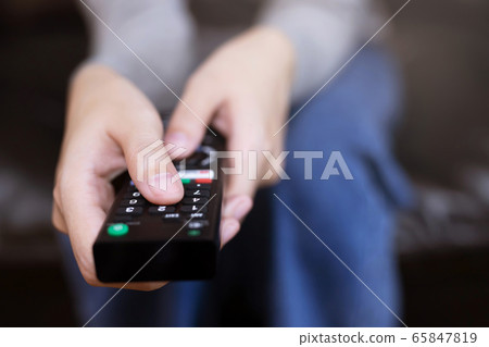 A woman is watching a soccer moment on the TV A woman is watching a soccer moment on the TV 65847819