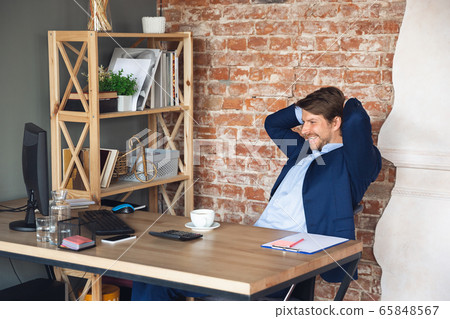 Young man, manager, team led return to work in his office after quarantine, feels happy and inspired 65848567