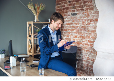 Young man, manager, team led return to work in his office after quarantine, feels happy and inspired 65848588