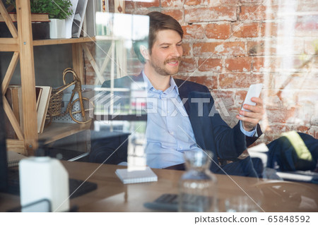 Young man, manager, team led return to work in his office after quarantine, feels happy and inspired Young man, manager, team led return to work in his office after quarantine, feels happy and inspired 65848592