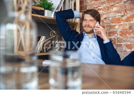 Young man, manager, team led return to work in his office after quarantine, feels happy and inspired Young man, manager, team led return to work in his office after quarantine, feels happy and inspired 65848594