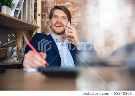 Young man, manager, team led return to work in his office after quarantine, feels happy and inspired Young man, manager, team led return to work in his office after quarantine, feels happy and inspired 65848596